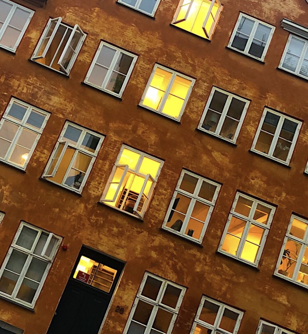Ett färgfotografi på ett hus med några fönster öppna.
